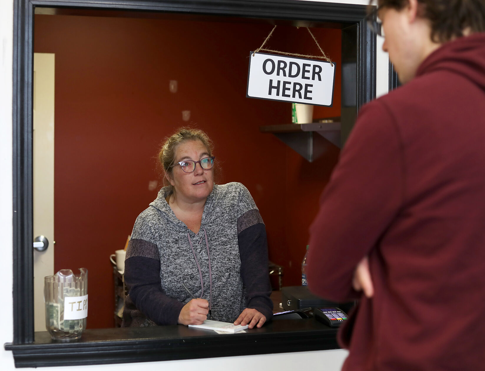 Old Neighborhood Cafe owner Vanessa Leitza takes customer Isaac Parrishโs order